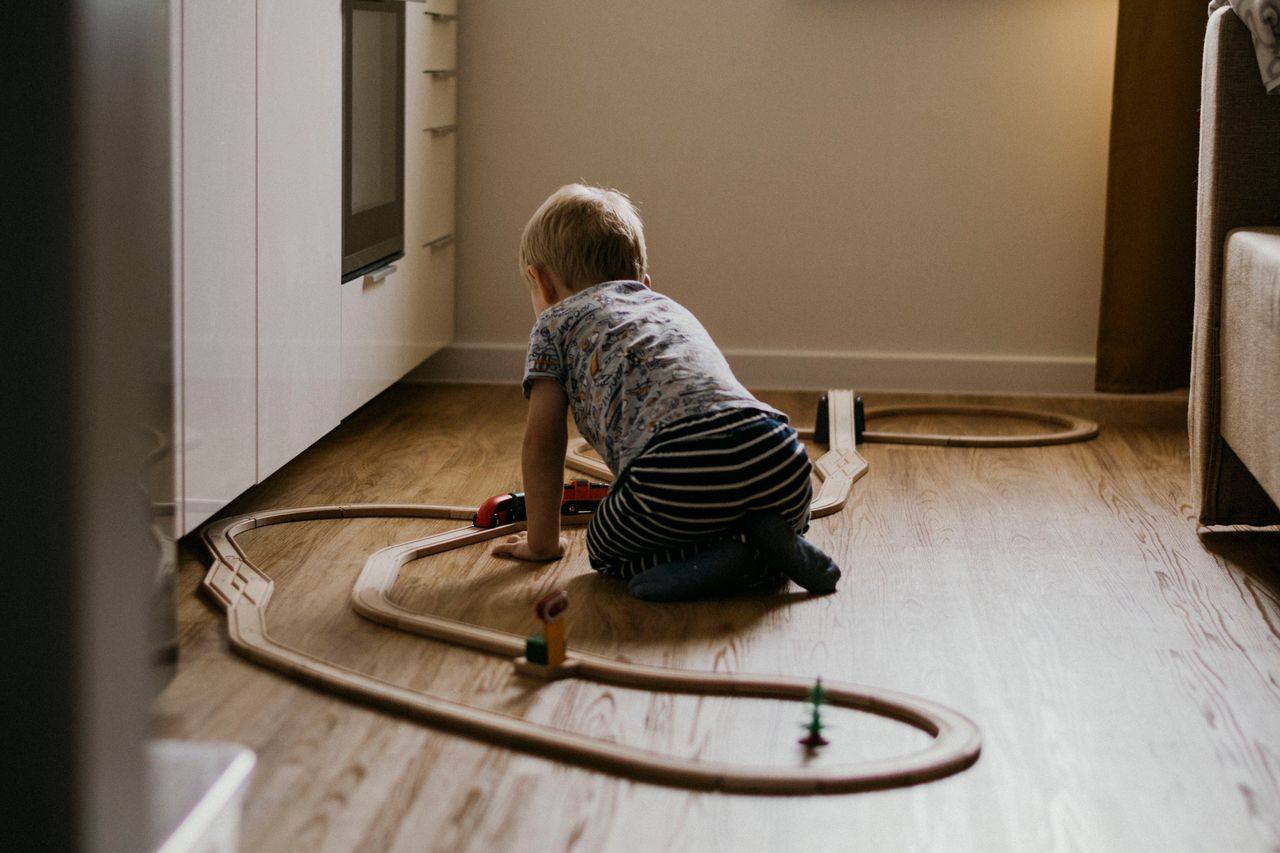 Bambino che gioca sul pavimento caldo di casa